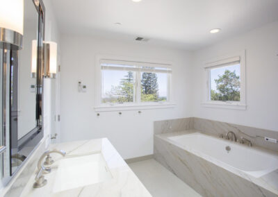bathroom with marble bathtub surround and matching sink