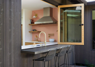 patio bar seating at a retractable accordion window that opens the kitchen up to the outdoors