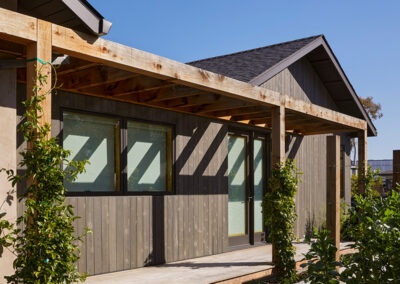 residential home exterior featuring a natural wood pergola over a wrap around porch patio