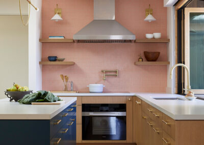 modern kitchen featuring salmon color wall tile, natural wood floor and cabinetry, and navy blue island